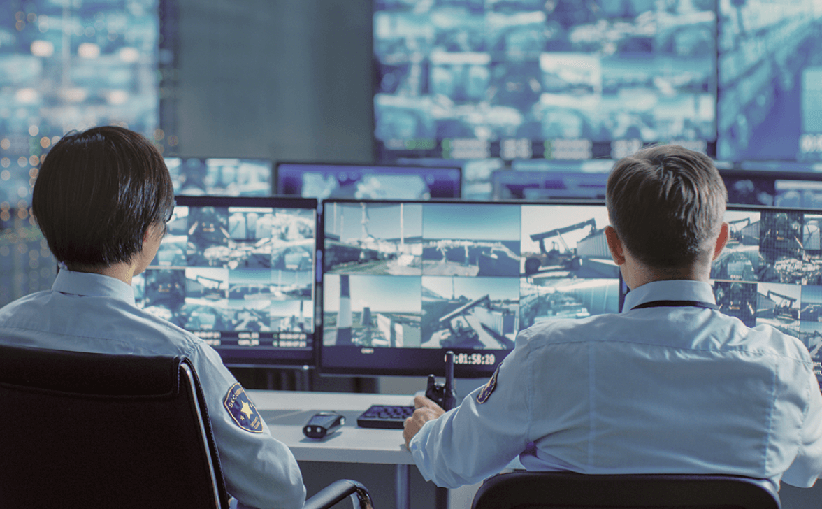 security guards looking at surveillance camera monitors