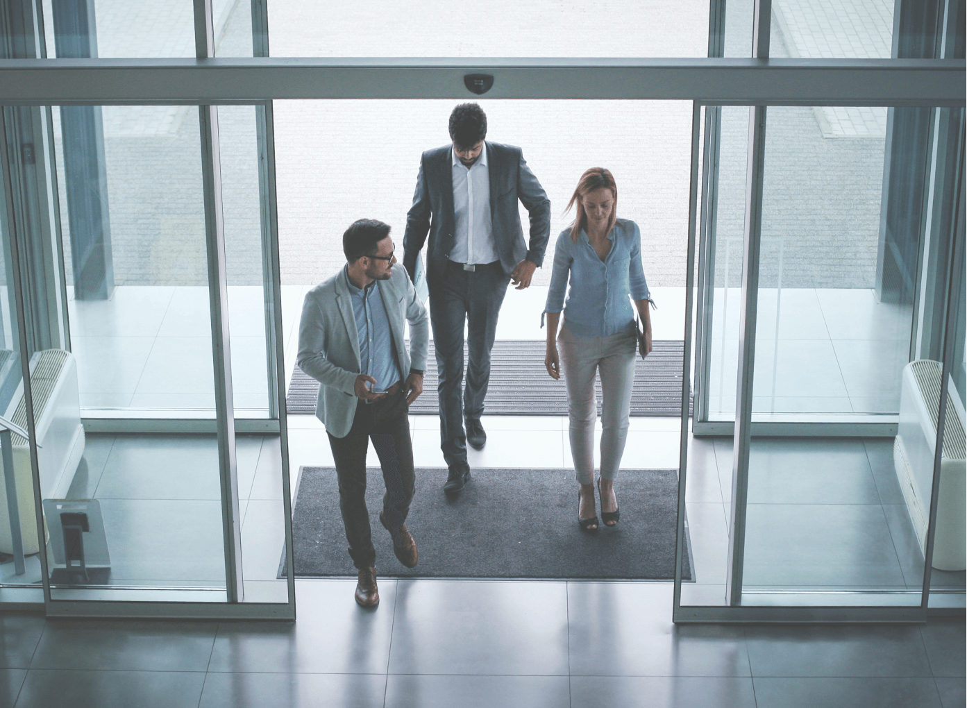 Three people entering a building